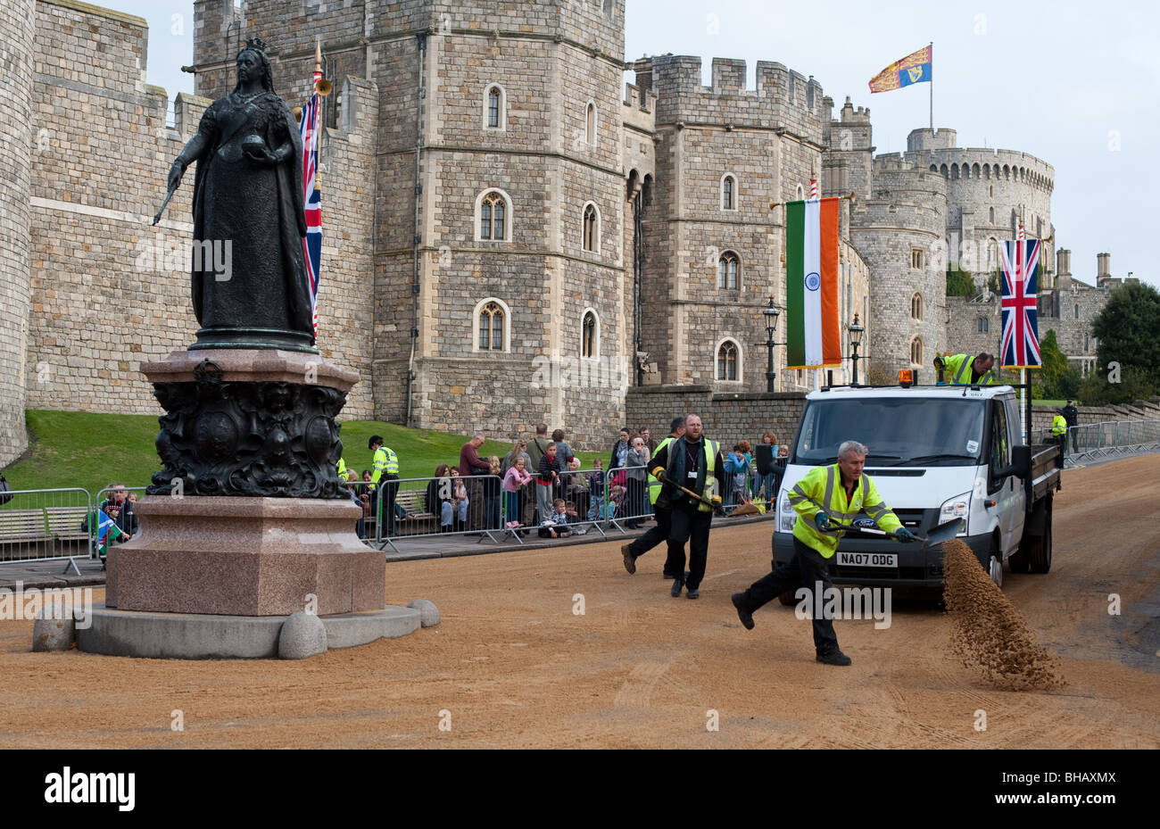 I lavoratori che copre le strade nelle vicinanze del Castello di Windsor con sabbia davanti alla processione in occasione di una visita di stato Foto Stock