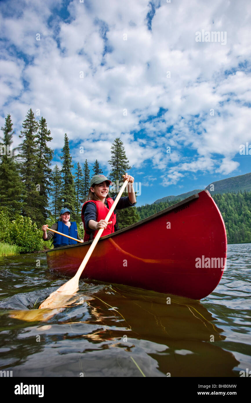 Madre e figlia paddling una canoa insieme sul lago Byers, estate, Denali State Park, centromeridionale Alaska, Stati Uniti d'America. Foto Stock