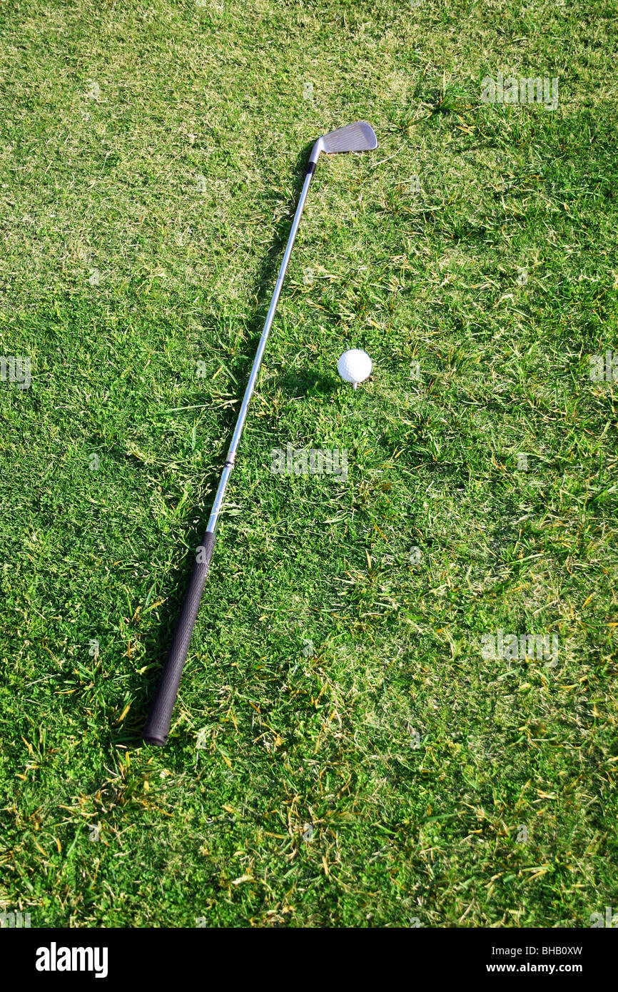 Golf club il ferro si trova accanto a sfera su scatola a T Foto Stock