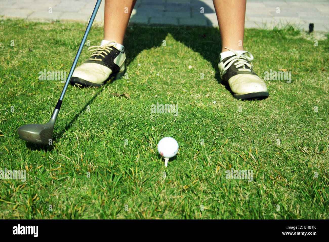 Il Golfer richiama club indietro per guidare dalla scatola a T con la palla sul tee bianco Foto Stock