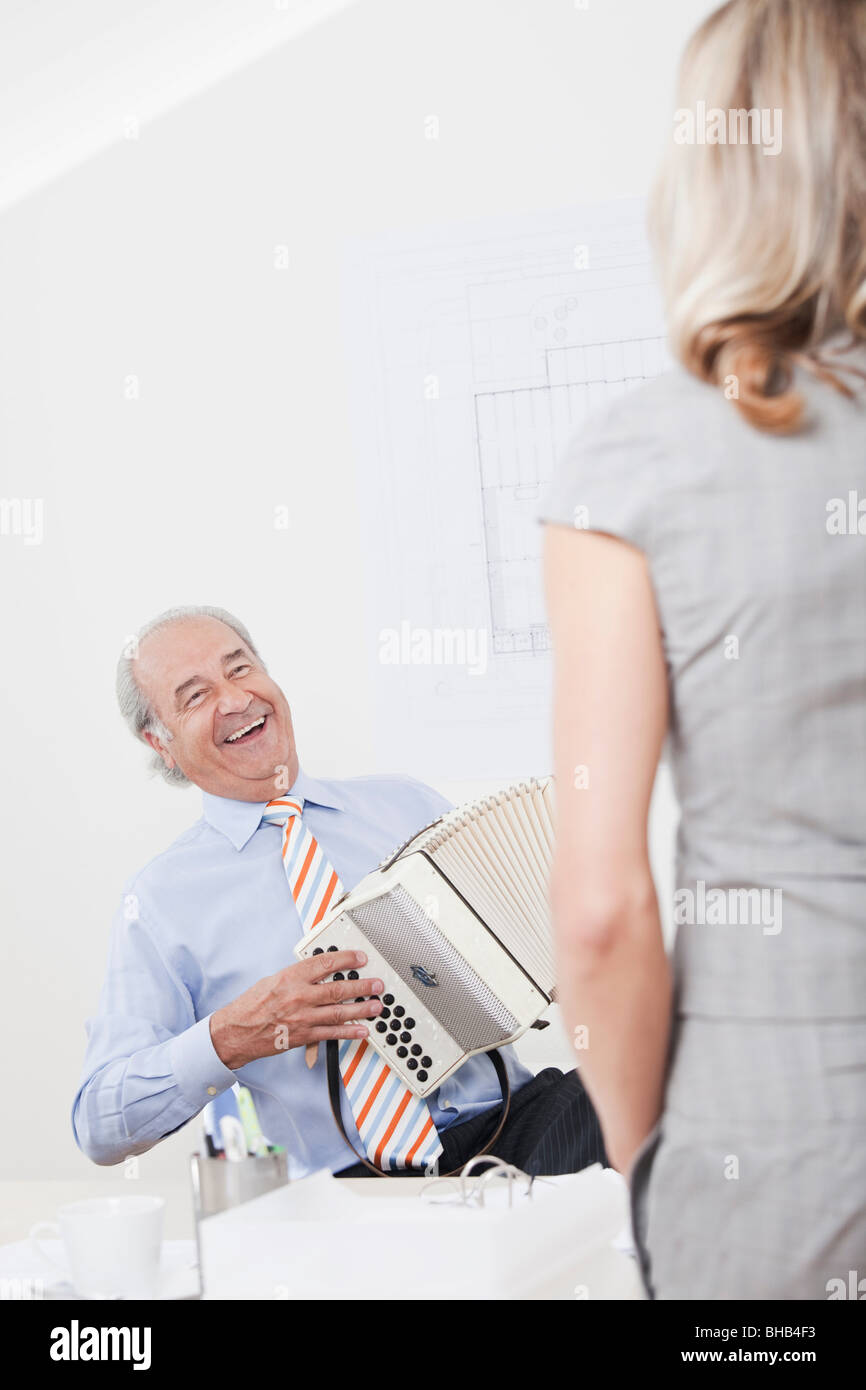 L'uomo la riproduzione di melodeon in un ufficio Foto Stock