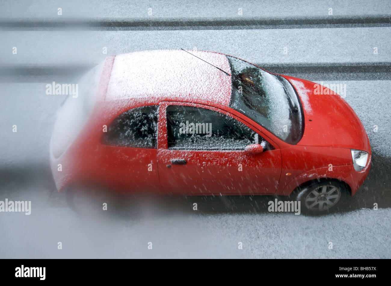 Rosso auto parcheggiate in strada di neve Foto Stock