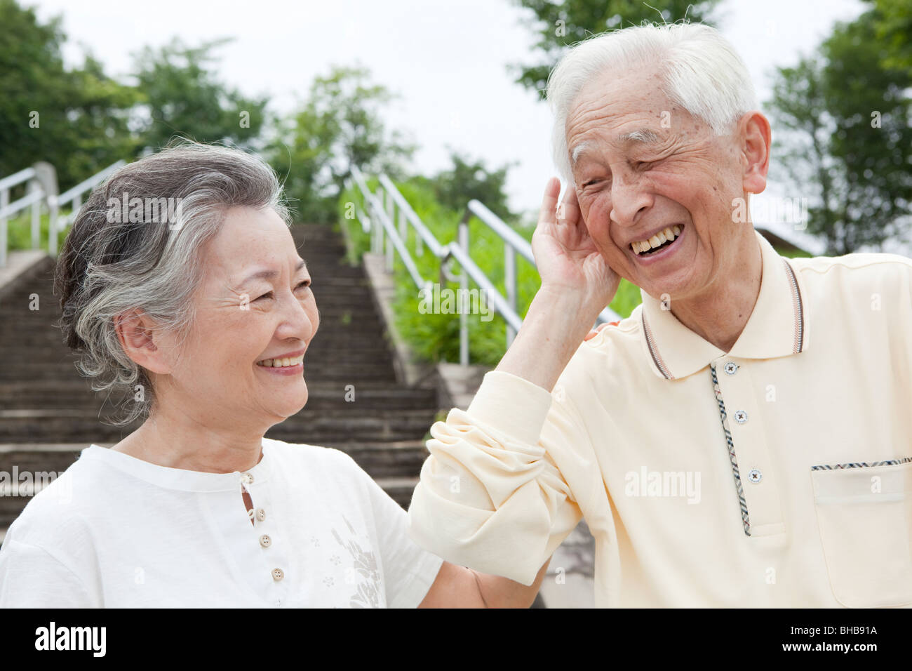 Giappone, Prefettura di Tokyo, Senior uomo che ascolta donna, sorridente, close-up Foto Stock