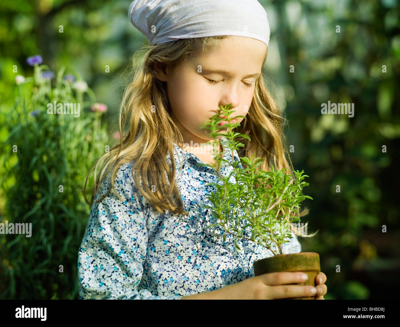 Giovani femmine odorare un impianto di erbe Foto Stock