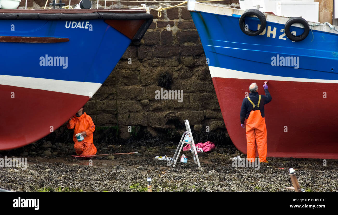 La pittura di pescatori le loro barche in Cromarty, Scozia Foto Stock