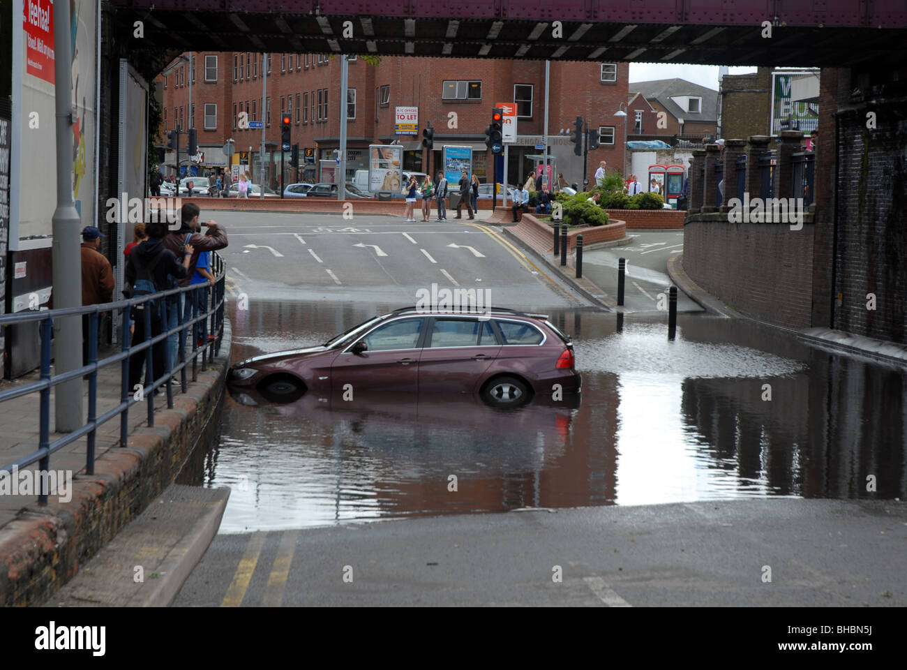 BMW Auto galleggianti in acqua di inondazione dopo forti piogge e scarichi bloccati ha causato a bloccarsi sotto il ponte ferroviario a Kingston, Londra SW Foto Stock