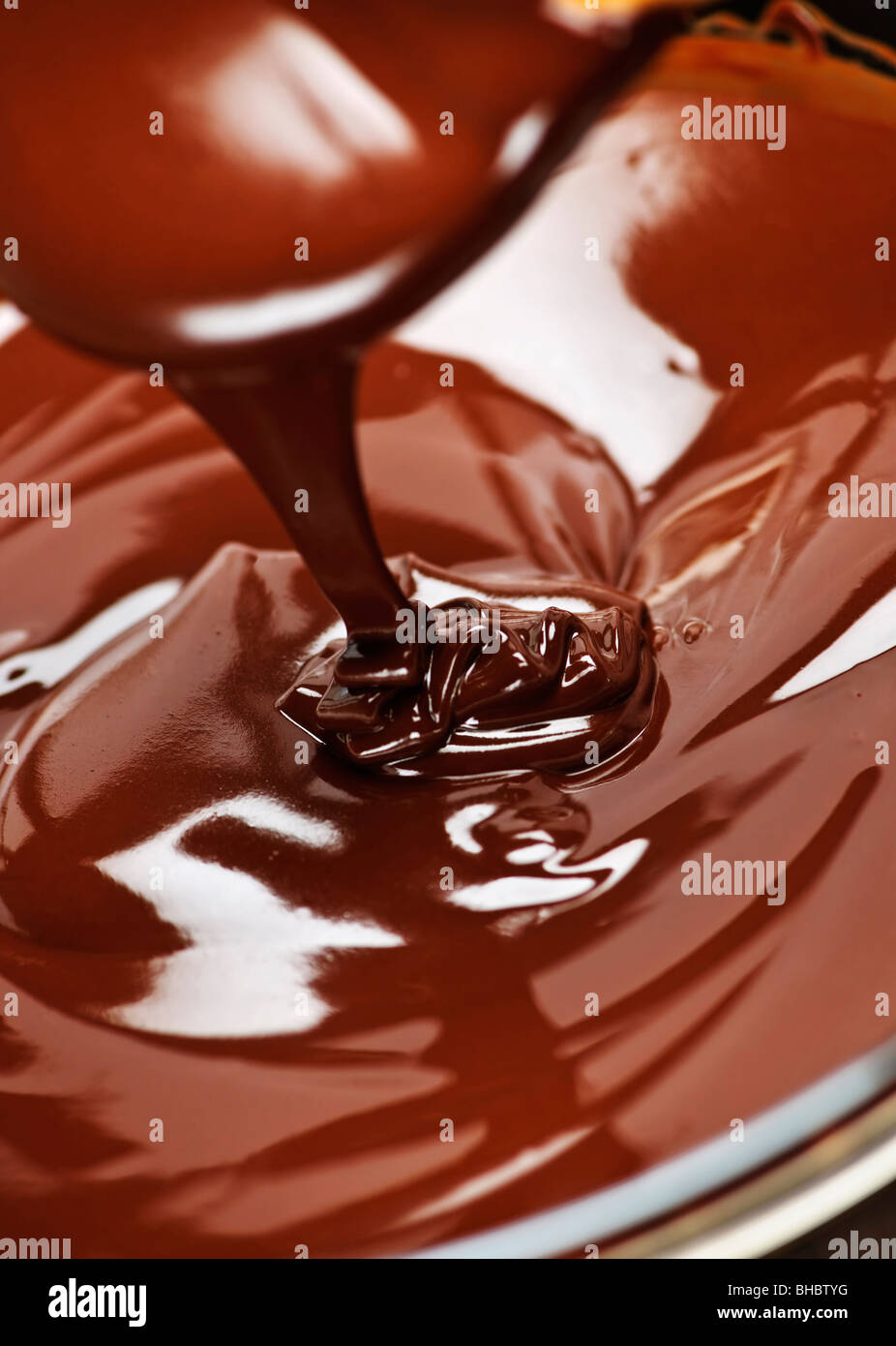 Fuso cioccolato scuro e ricco gocciolamenti dal cucchiaio Foto Stock