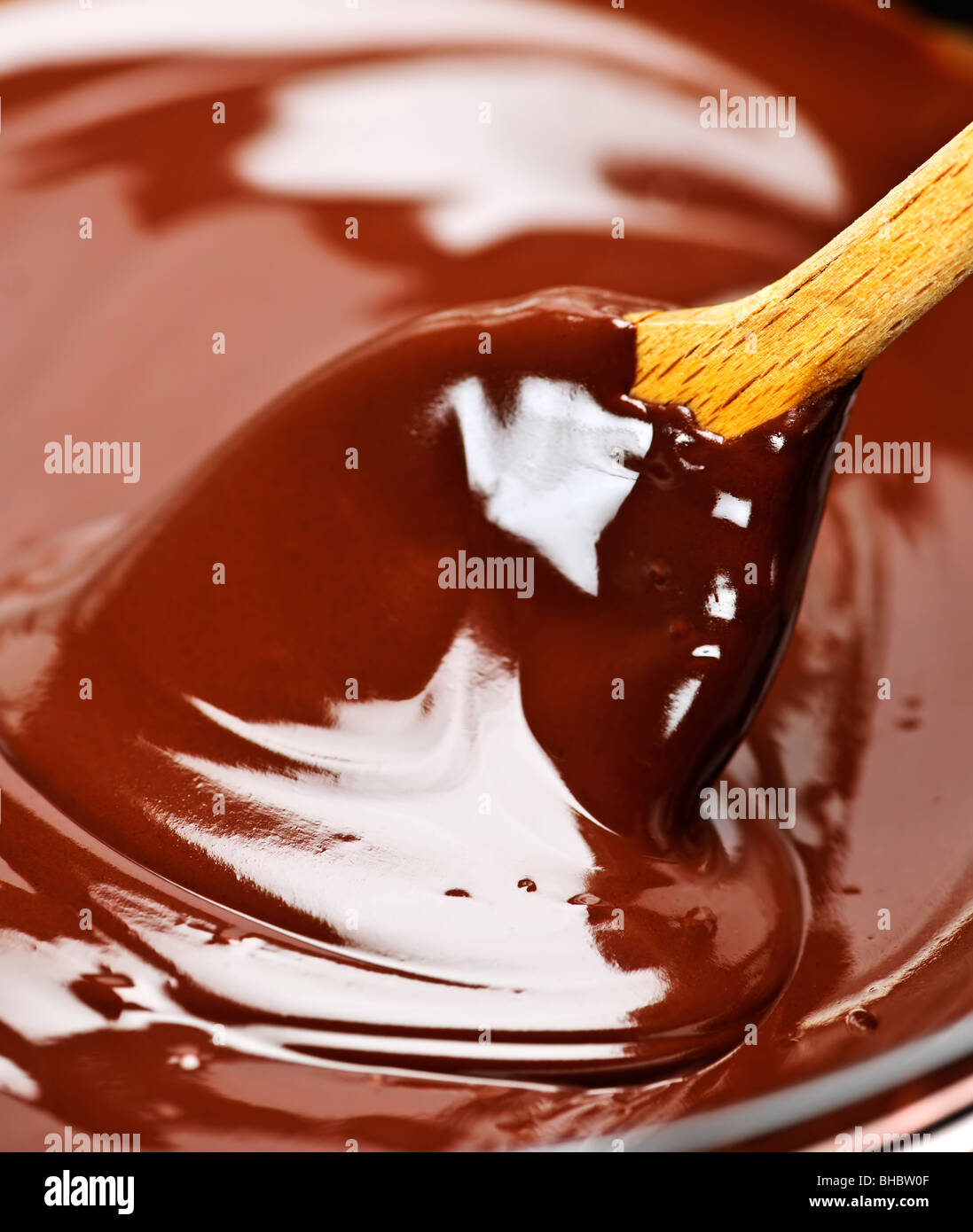 Il cucchiaio di legno morbido di agitazione del fuso di cioccolato ricco Foto Stock