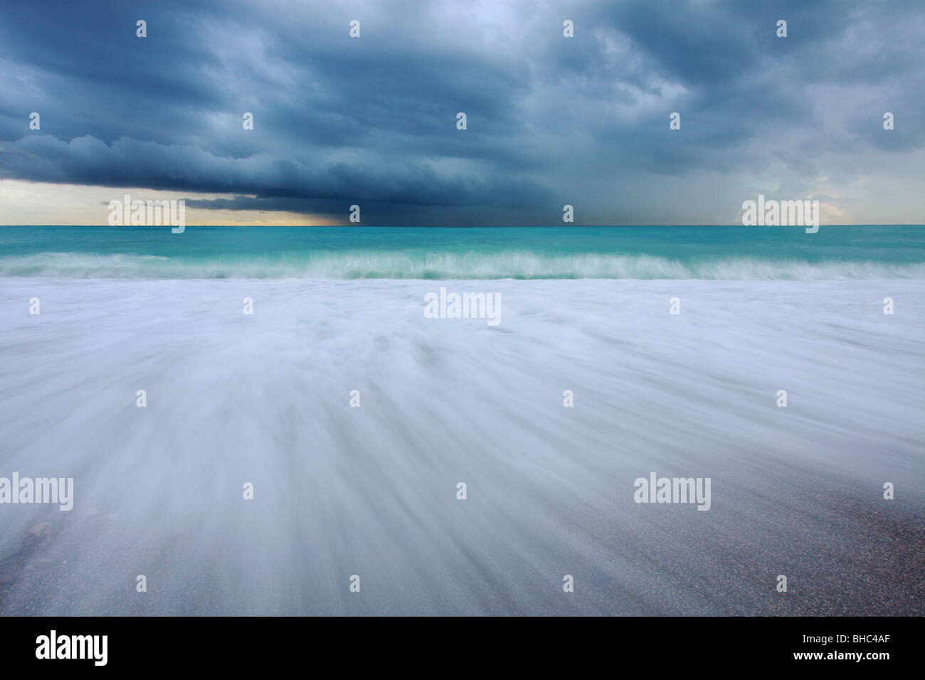 La spiaggia di Nizza sotto un clima burrascoso e nuvoloso giorno fotografato con un obiettivo grandangolare con una bassa esposizione Foto Stock