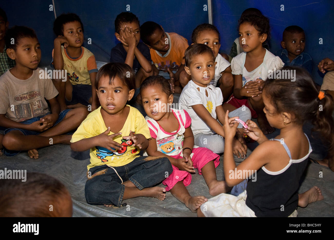 Bambini godendo di attività di gruppo gestito da Plan International presso IDP sfollati camp Dili Timor Orientale Foto Stock