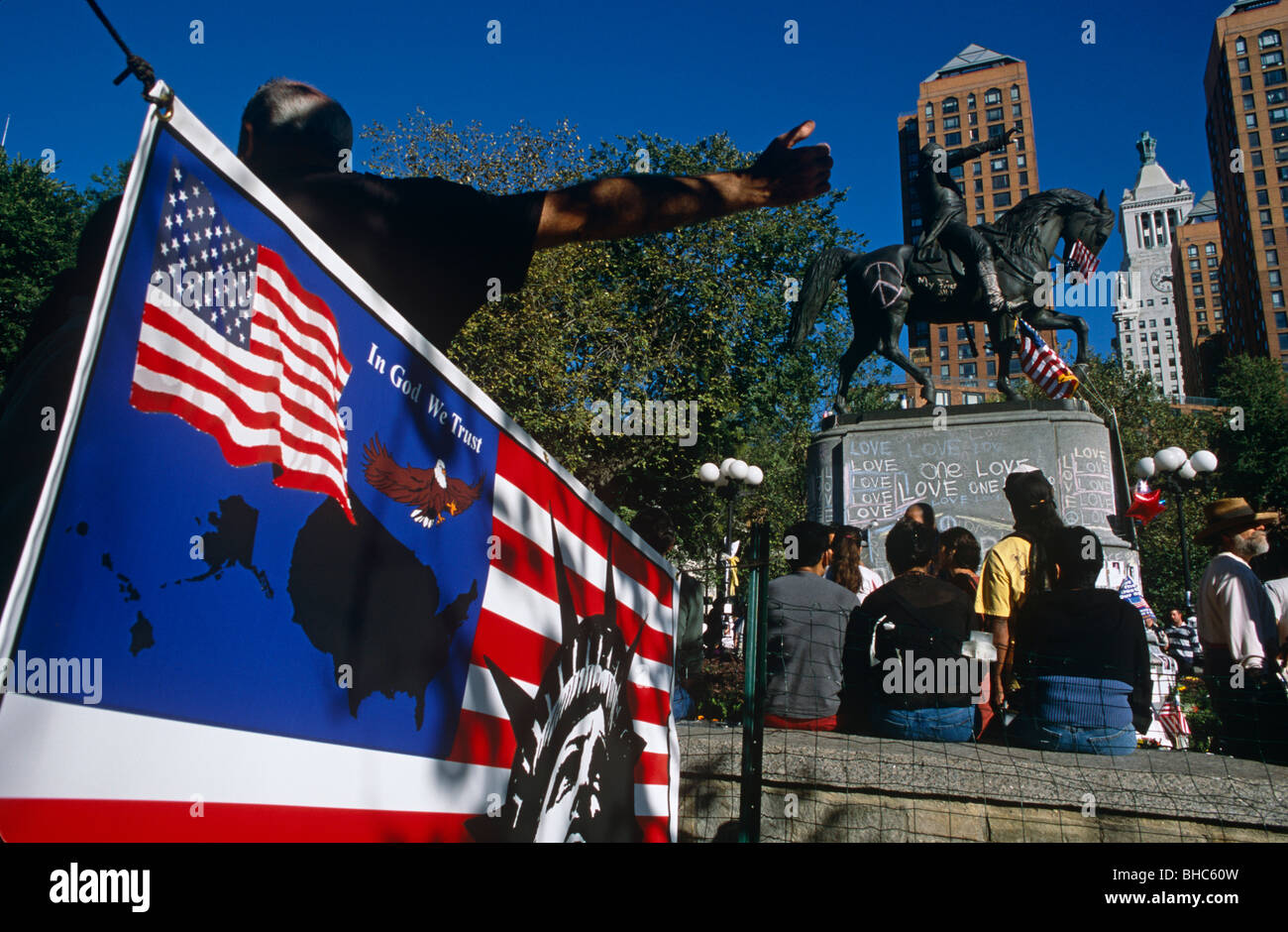 Un Americano di bandiere con le parole 'In God We Trust' si blocca in Union Square, Manhattan una settimana dopo 9/11. Foto Stock