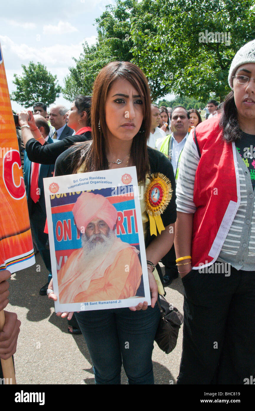 Ravidassia marzo contro la discriminazione di casta da sikh. Giovane donna con rosone e Sant Ramanand poster Foto Stock