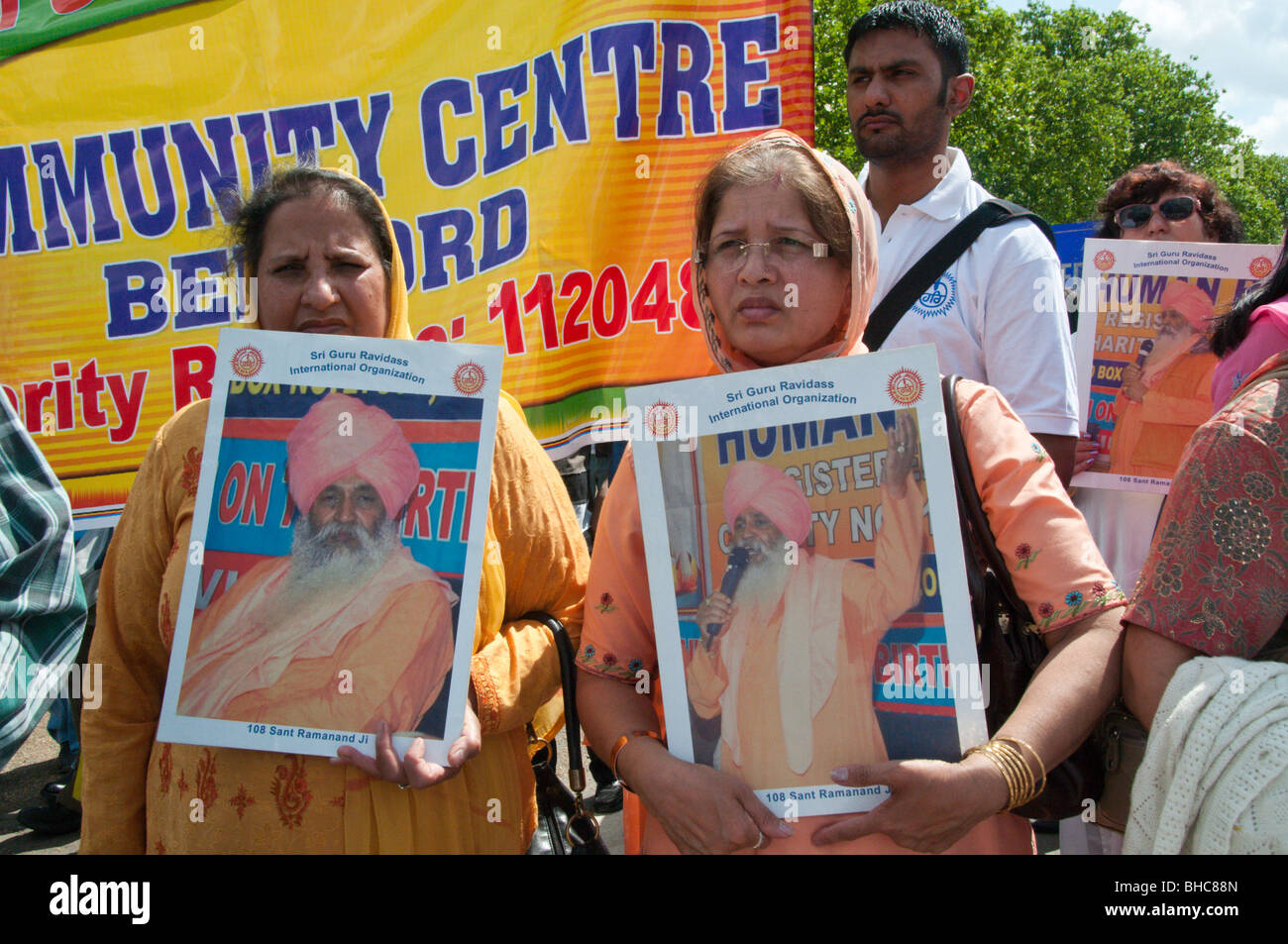 Ravidassia marzo contro la discriminazione di casta da sikh. Le donne con Sant Ramanand poster nella parte anteriore del banner Foto Stock