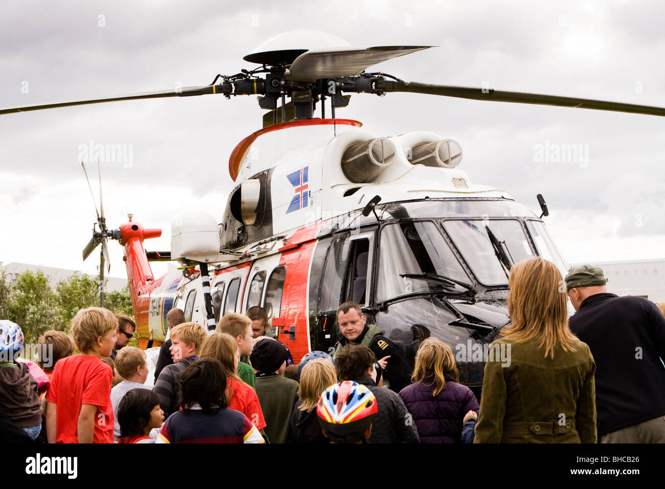 Le persone si radunano attorno ad un elicottero da la Icelandic Coast Guard, Vogar in Vatnsleysustrond, Islanda. Foto Stock