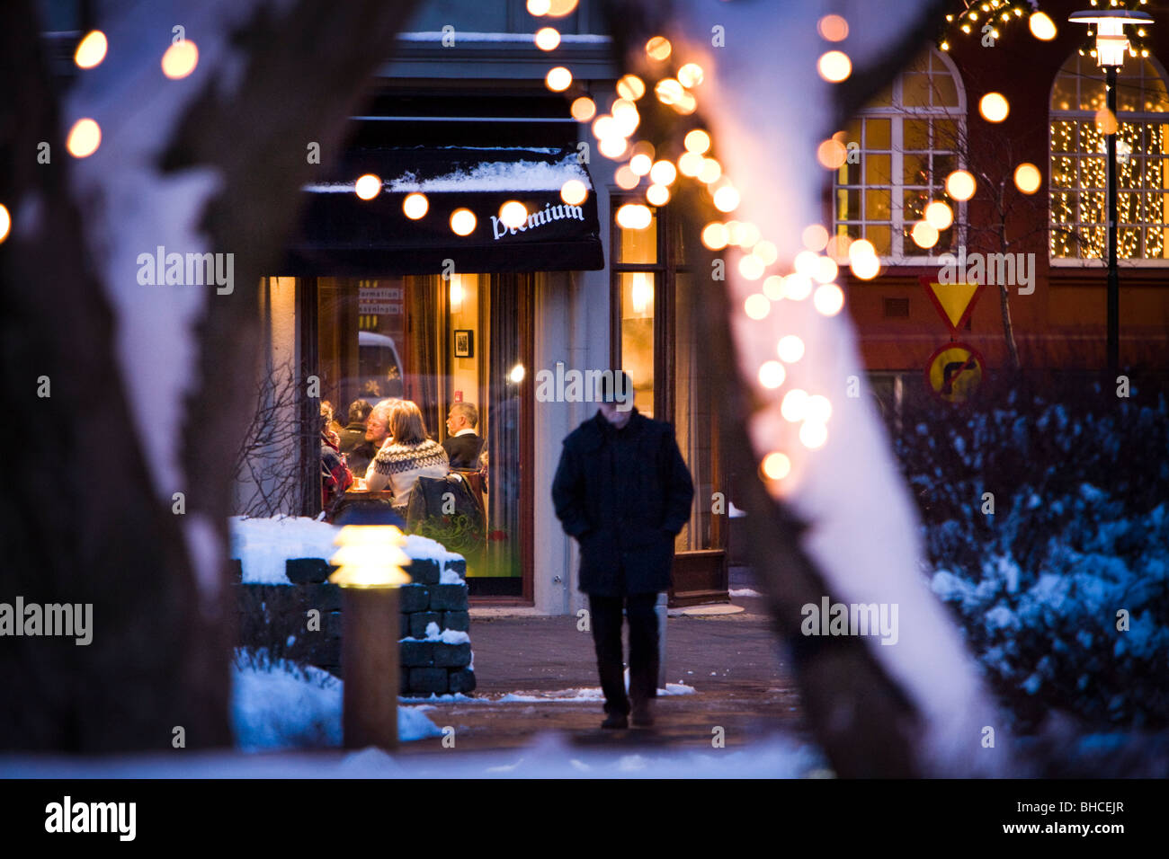 Persona che cammina e persone sedute all'interno di 'CaféParís'. Il centro di Reykjavik Islanda Foto Stock