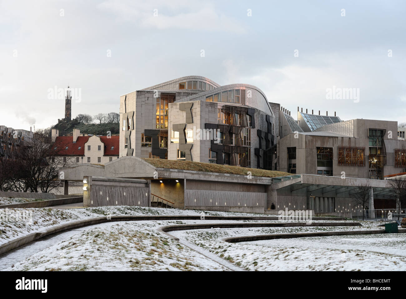 Edificio del Parlamento scozzese, Holyrood, Edimburgo, Scozia, nella neve al crepuscolo. Calton Hill è in background. Foto Stock