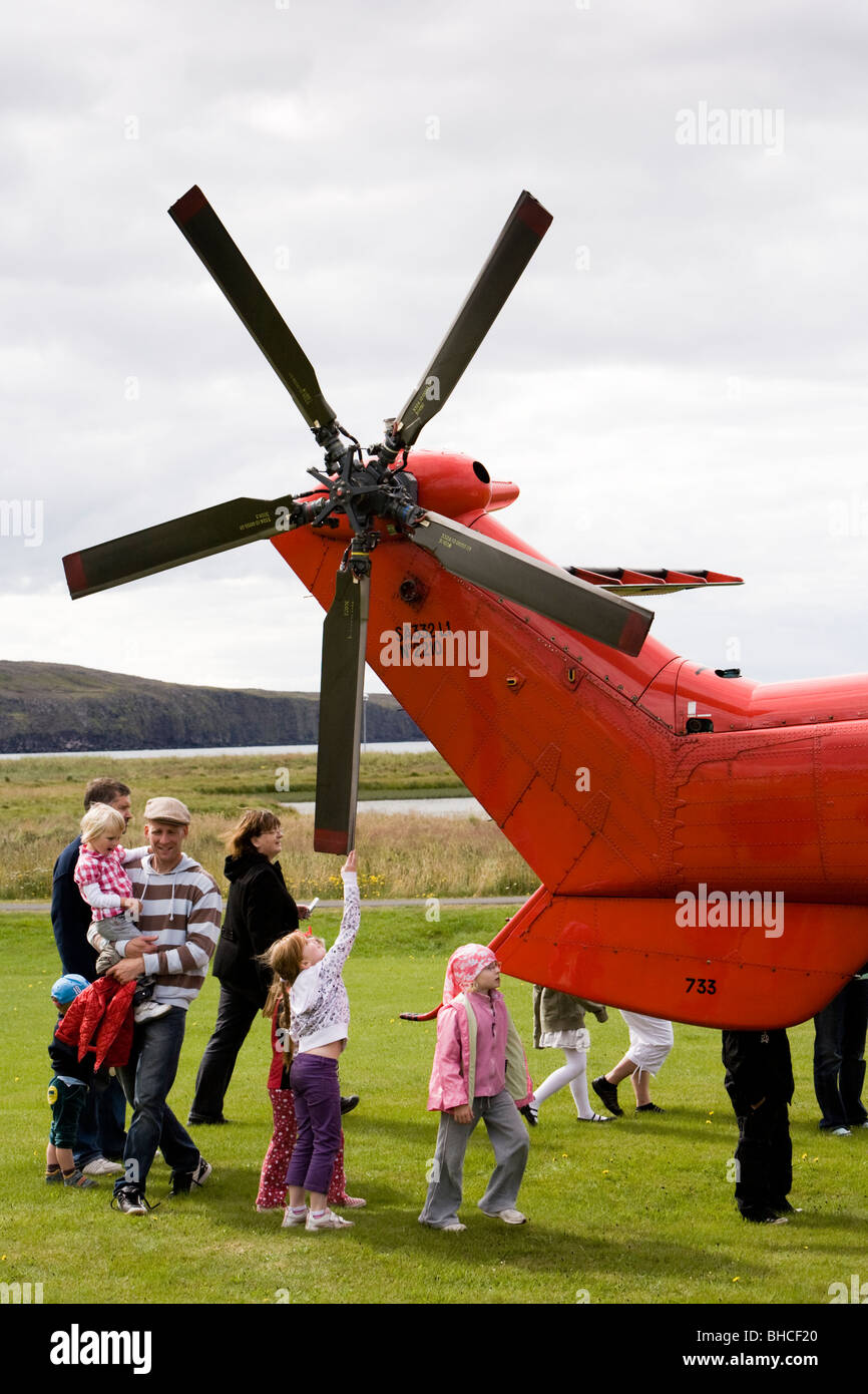 Le persone si radunano attorno ad un elicottero da la Icelandic Coast Guard, Vogar in Vatnsleysustrond, Islanda. Foto Stock