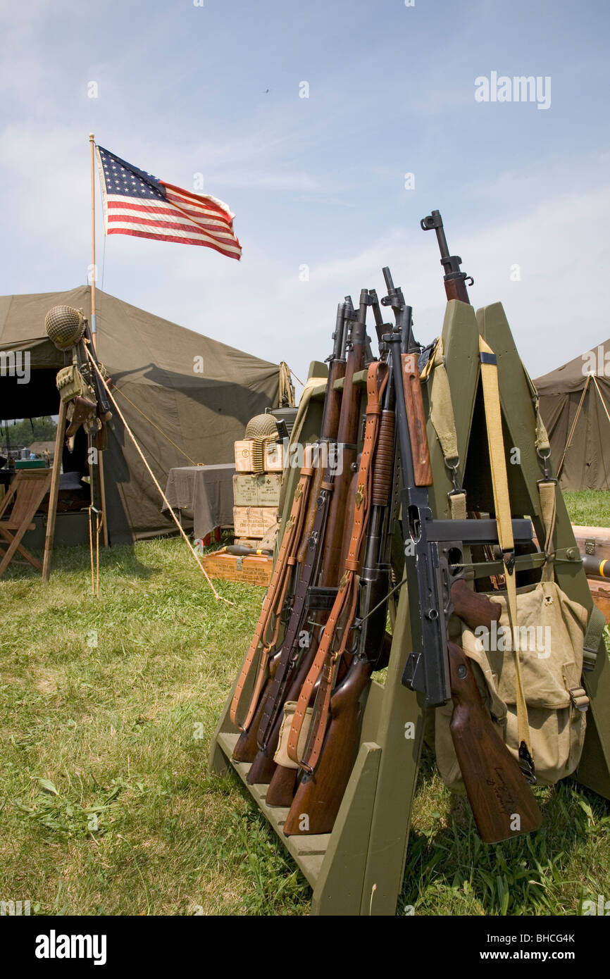 48 stelle della bandiera americana volando sopra la tenda dell'esercito con i fucili in primo piano, alla rievocazione storica della II Guerra Mondiale a Mid-Atlantic Air Museum Foto Stock