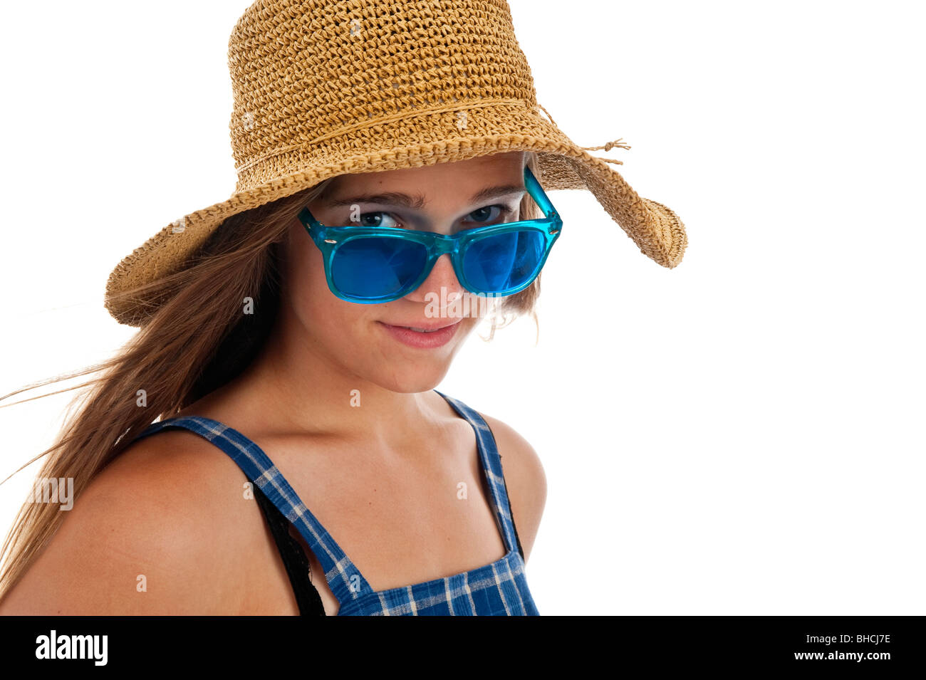 Pretty girl teen in blu di occhiali da sole e un cappello di paglia Foto Stock