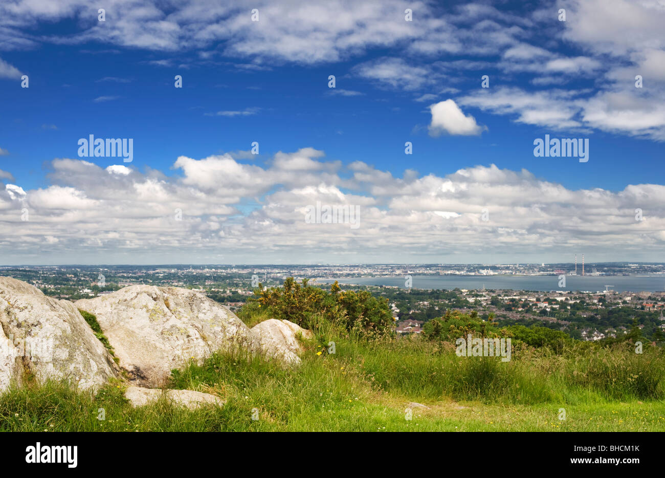 Vista dal nord oltre la rete DUN Laoighaire e la baia di Dublino, da Killiney Hill, con affioramento di Leinster Granito in primo piano Foto Stock