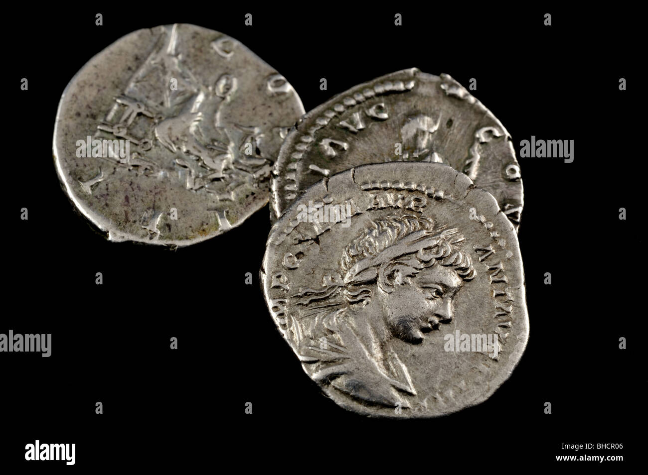 Romano isolato tre monete su uno sfondo nero Foto Stock