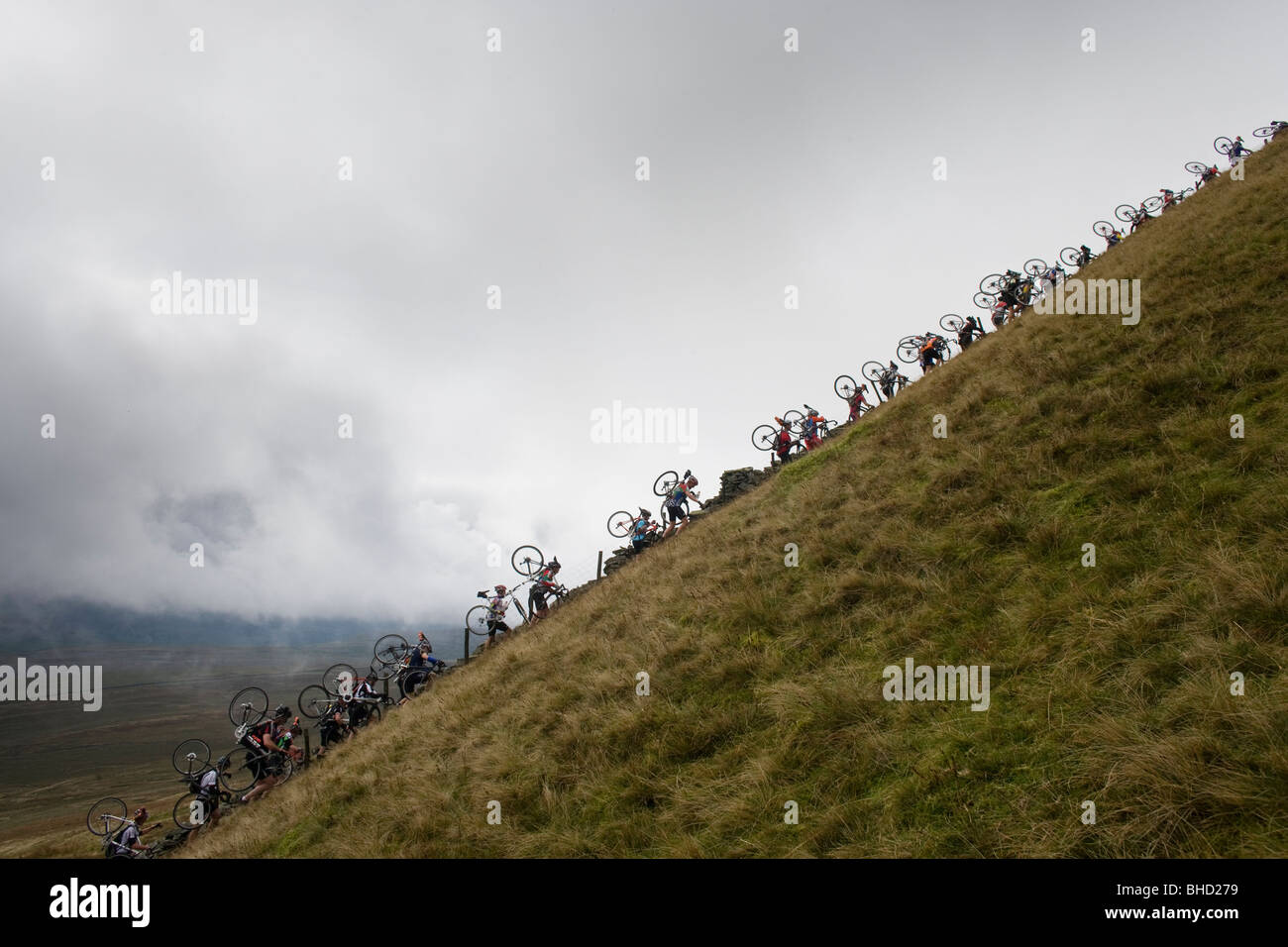 La Folla di ciclisti portano le loro biciclette in montagna durante la Tre Cime Cyclo-Cross nello Yorkshire, Regno Unito Foto Stock