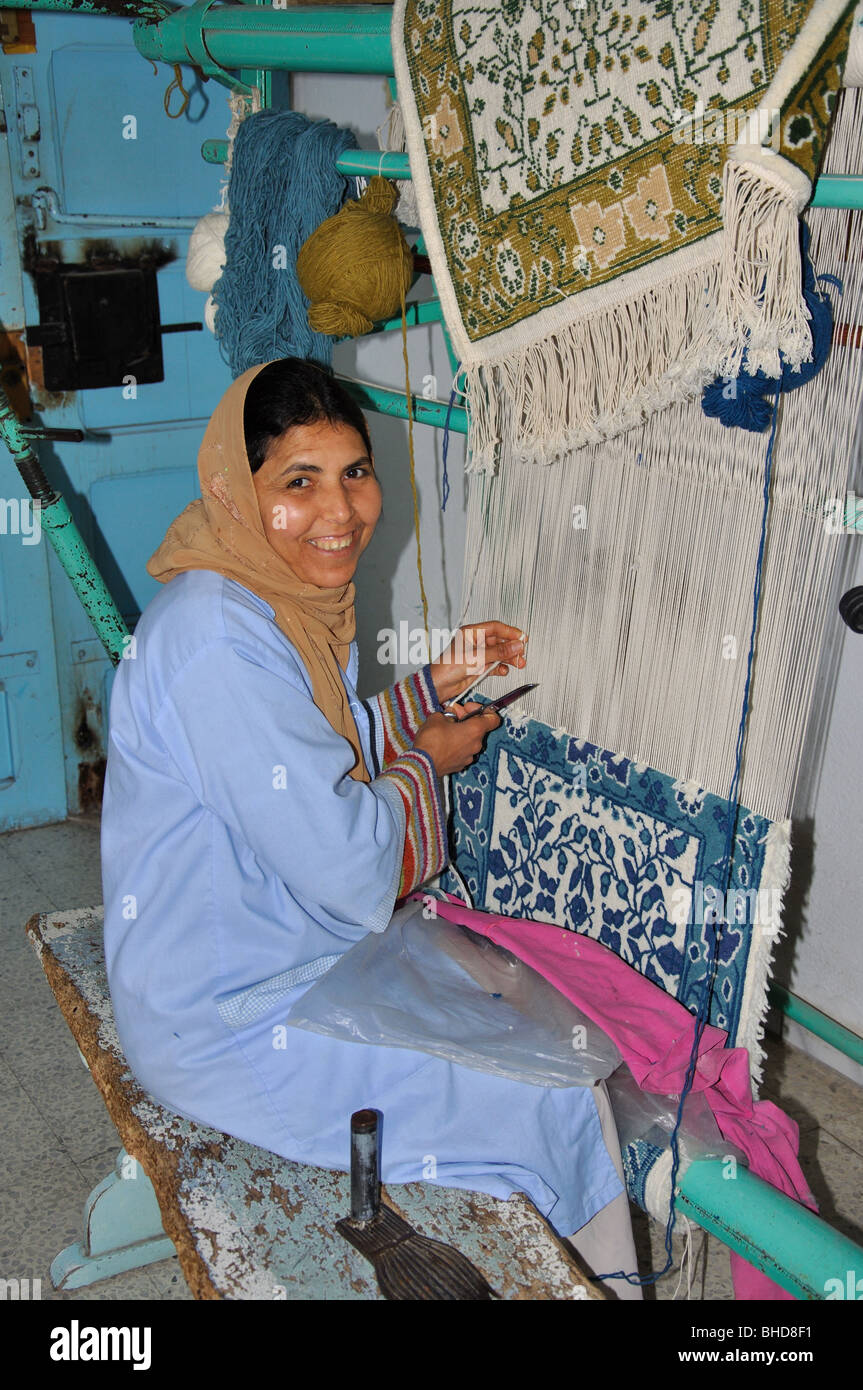 Giovane donna araba rendendo tappeto sul telaio, Sousse Marina, Sousse, Sousse Governatorato, Tunisia Foto Stock