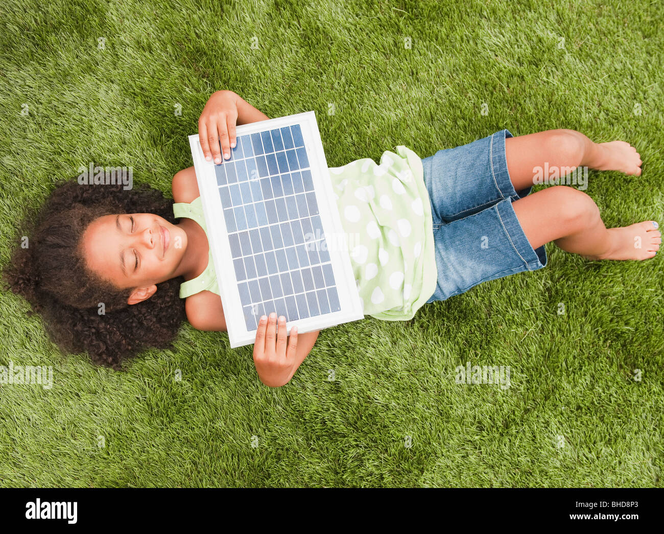 Razza mista ragazza posa con pannello solare Foto Stock