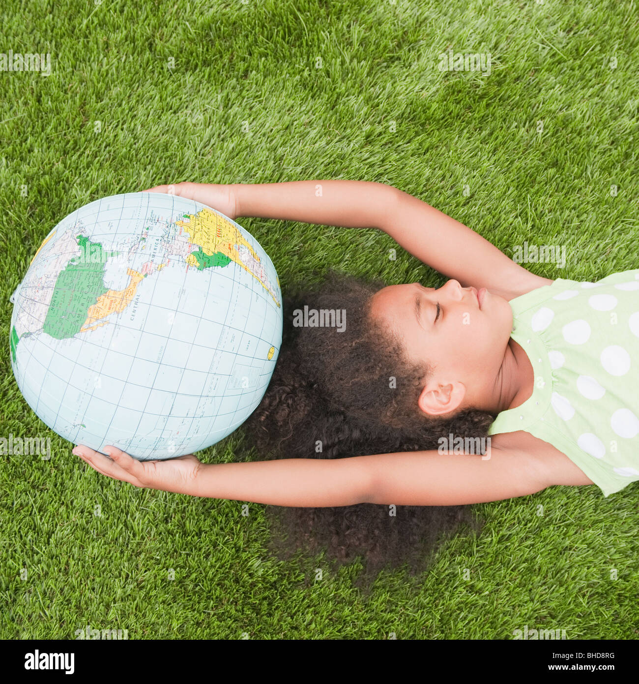 Razza mista girl holding globe Foto Stock
