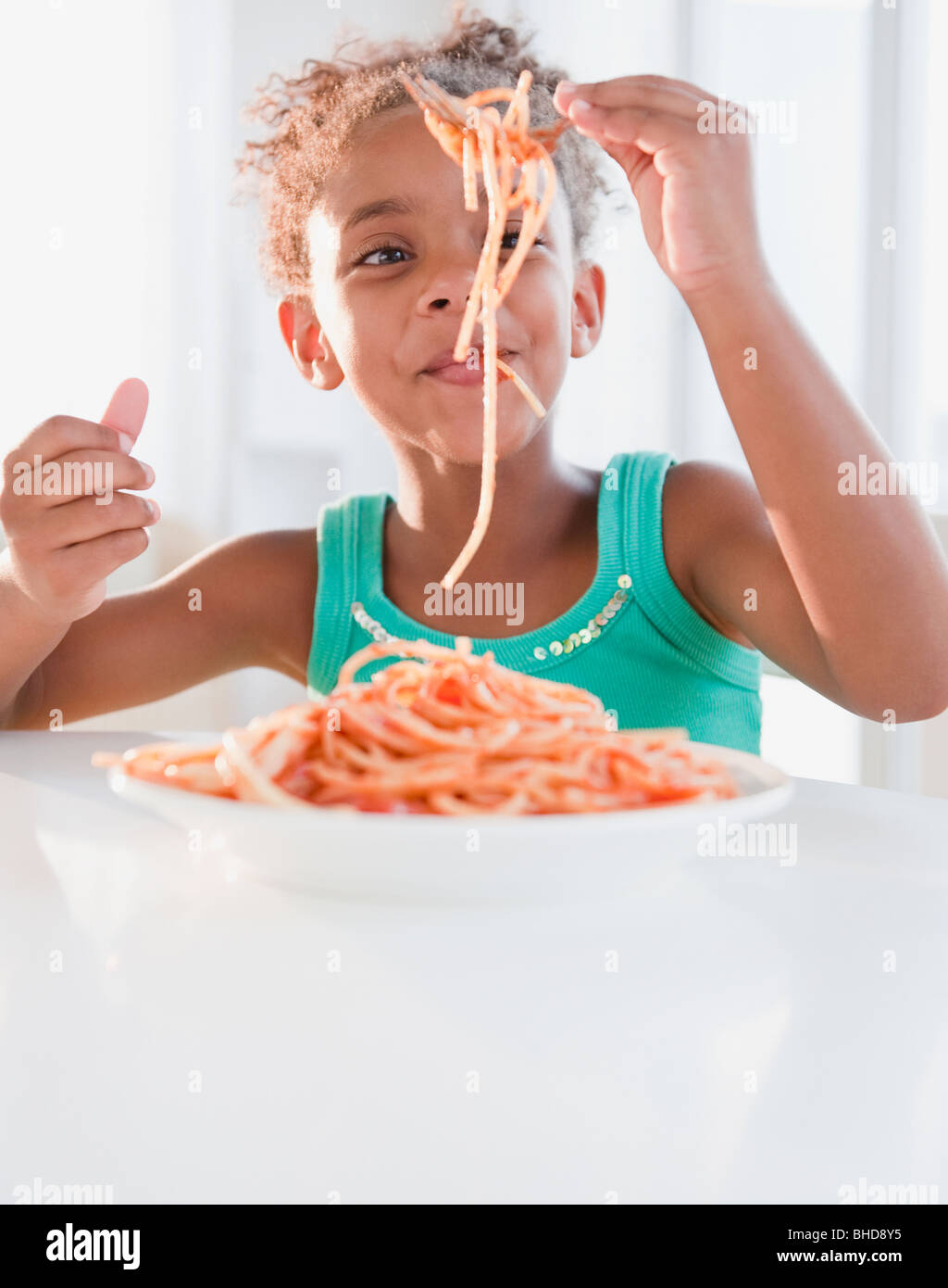 Razza mista ragazza mangiare spaghetti Foto Stock
