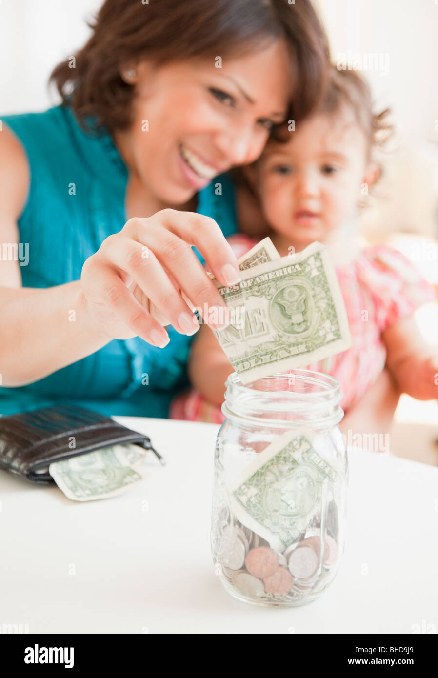 Ispanico madre e figlia di risparmio di denaro Foto Stock