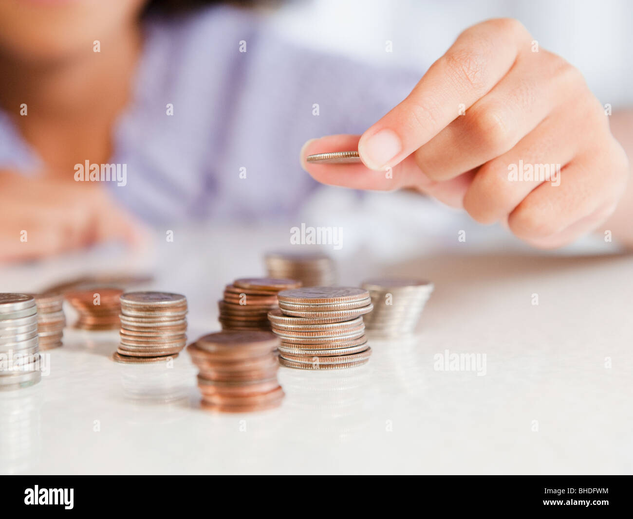 Ragazza ispanica monete di impilamento Foto Stock