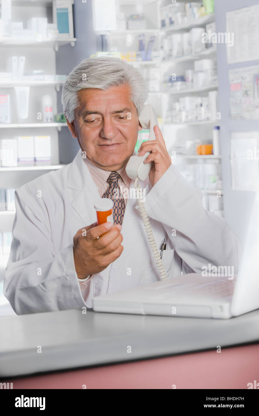 Farmacisti ispanica parlando al telefono Foto Stock