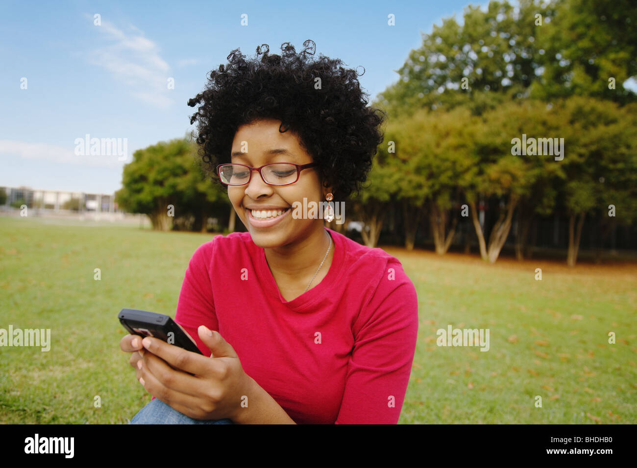 Razza mista donna di messaggistica di testo sul telefono cellulare Foto Stock