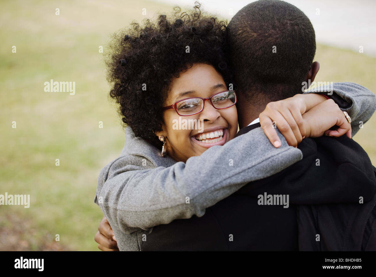 Sorridente razza mista donna abbracciando il fidanzato Foto Stock