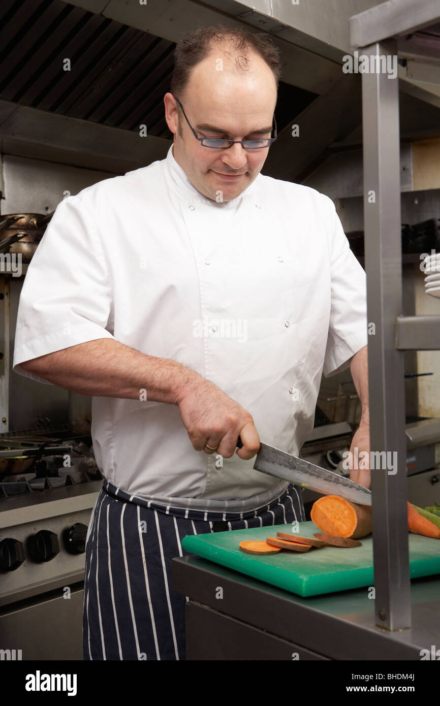 Lo Chef maschio preparare verdura nel ristorante cucina Foto Stock