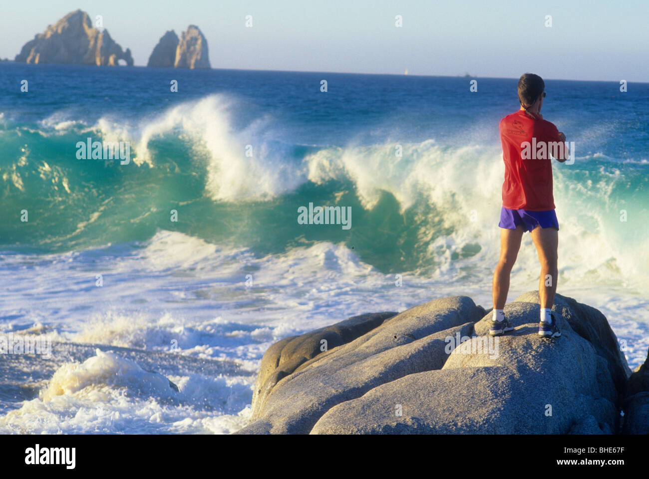 Uomo in piedi sulle rocce dall' oceano. Foto Stock