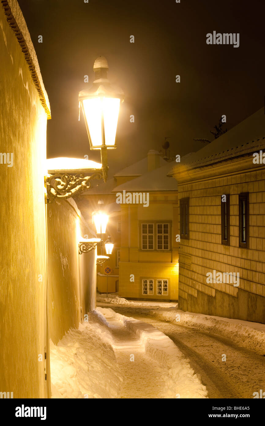 Praga - strada stretta a hradcany con lanterne a gas in inverno Foto Stock