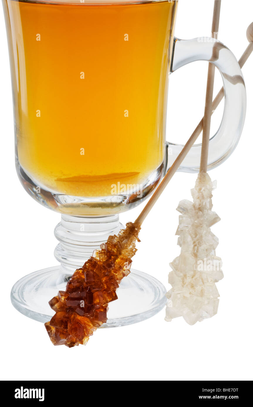 Tazza di tè con Dolce caramello zucchero su bastoni di legno di close-up su bianco. Foto Stock
