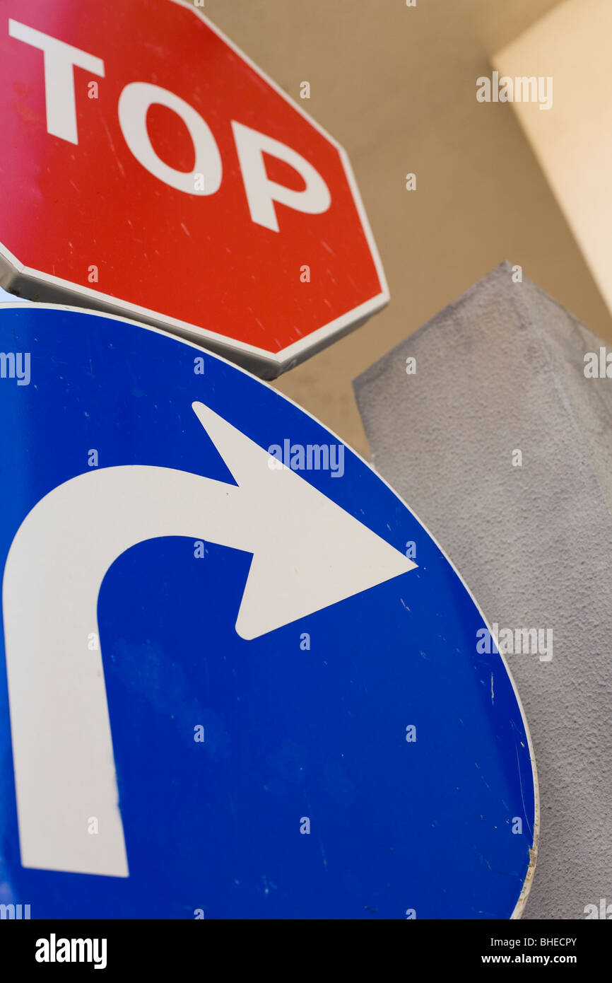 Un cartello blu punti a destra mentre la parte di un segnale di stop può essere visto sopra la freccia. Foto Stock
