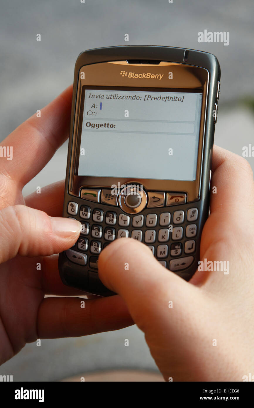 Una donna che utilizzano uno smartphone per scrivere un messaggio di posta elettronica Foto Stock