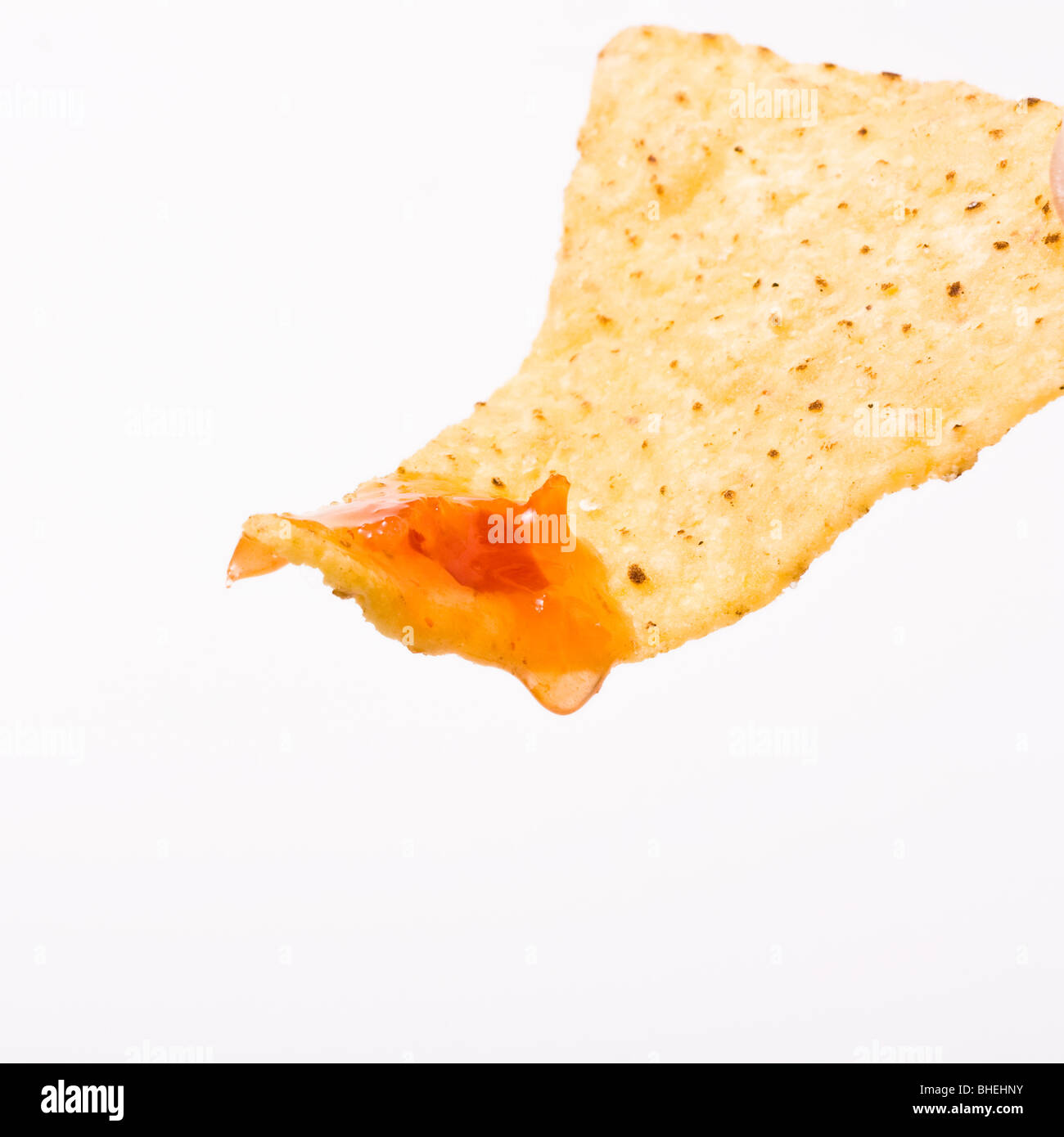 Tortilla Chips o nachos gocciolamento e colava salsa isolata contro uno sfondo bianco. Foto Stock