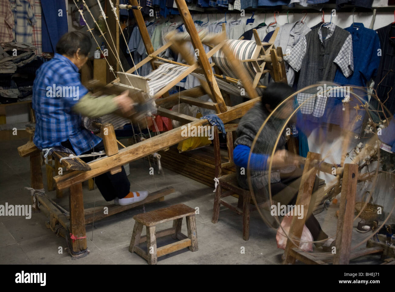 Le donne il funzionamento di un telaio di tessitura e filatura della ruota in corrispondenza del Venezia della Cina, Zhouzhuang, provincia dello Jiangsu, Cina e Asia Foto Stock