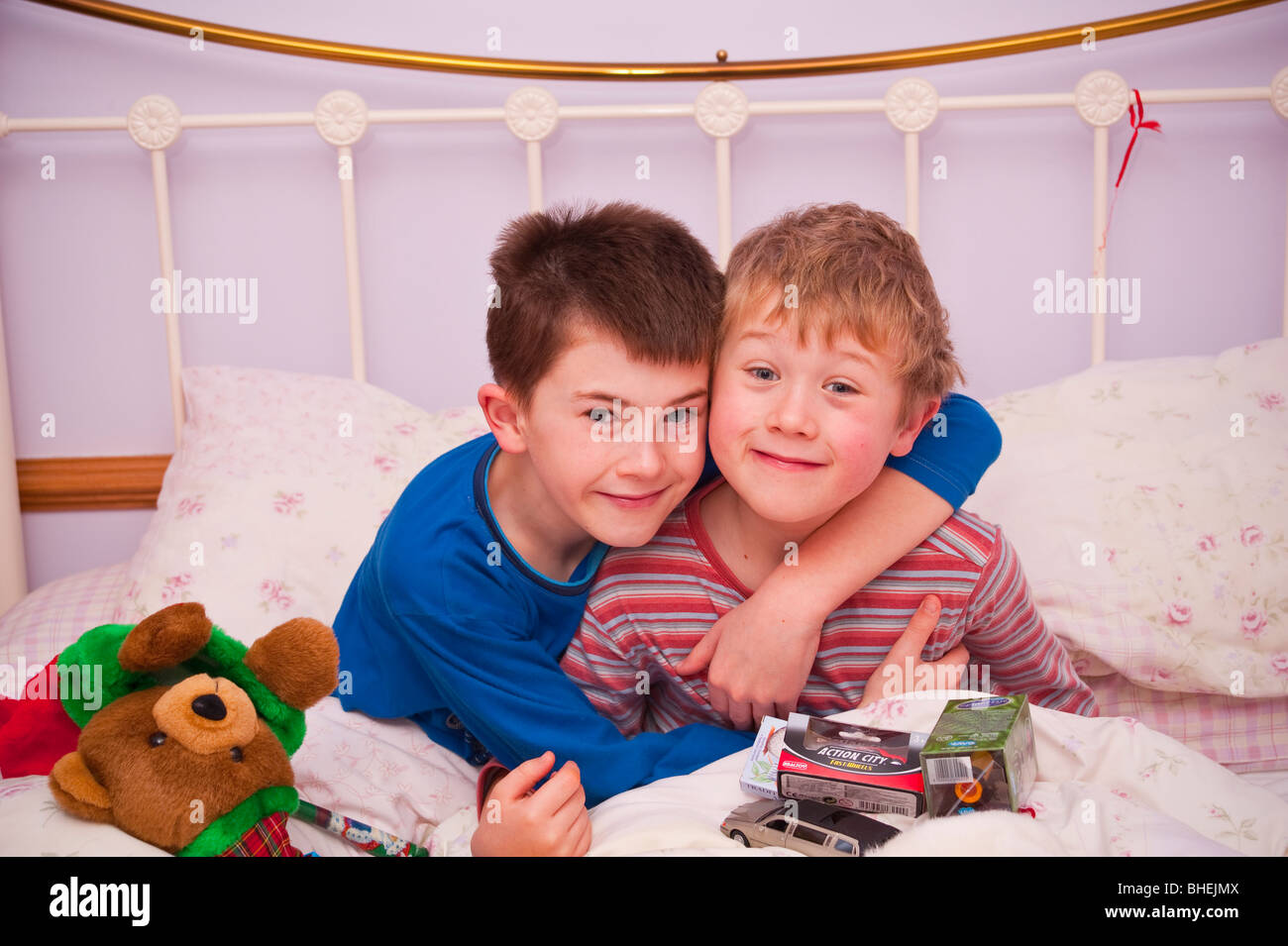 Un modello rilasciato foto di due fratelli aprendo le loro calze di Natale a letto nel Regno Unito Foto Stock