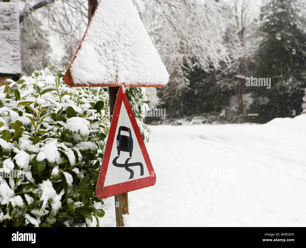 Pericolo, strada sdrucciolevole segno d'inverno. Foto Stock