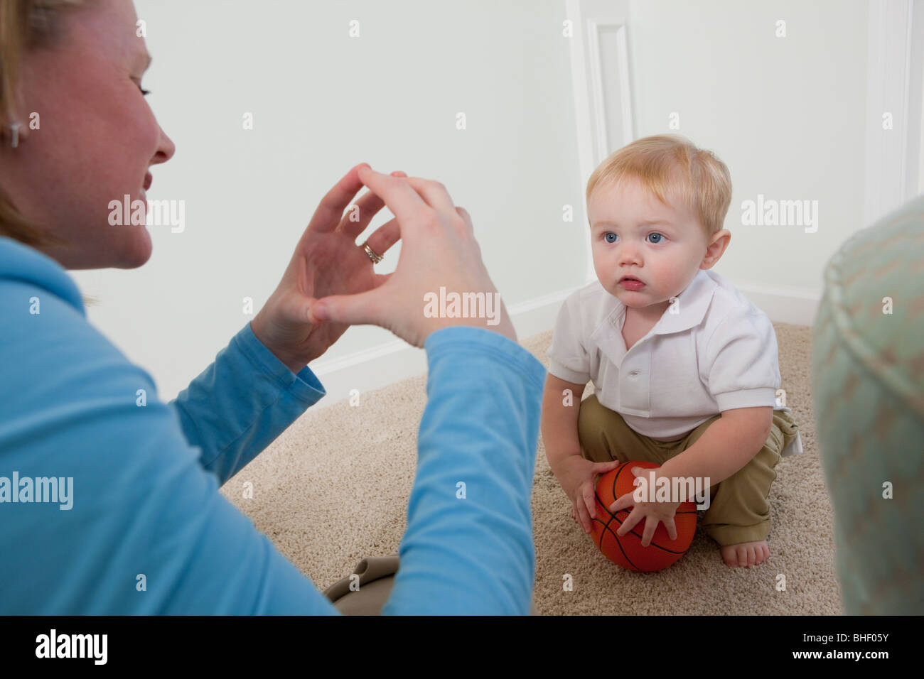 Donna firma la parola "Ball' in American Sign Language durante la comunicazione con il figlio Foto Stock