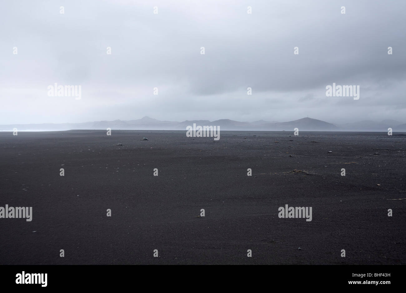 Scenario dalla spiaggia di sabbia di montagne, costa sud dell'Islanda Foto Stock