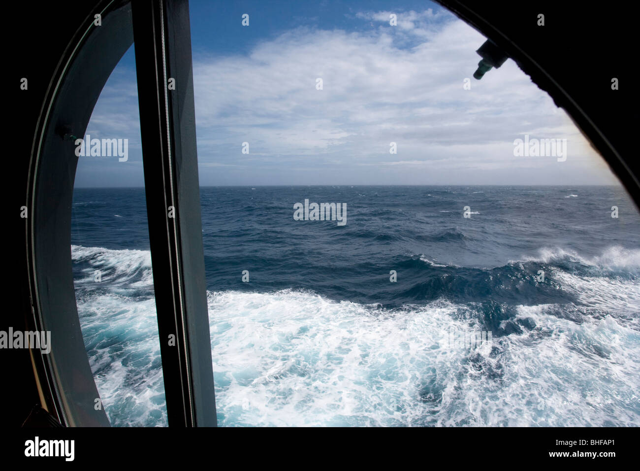 Vista dell'Oceano Atlantico e le onde attraverso un oblò, crociera Queen Mary 2 Foto Stock