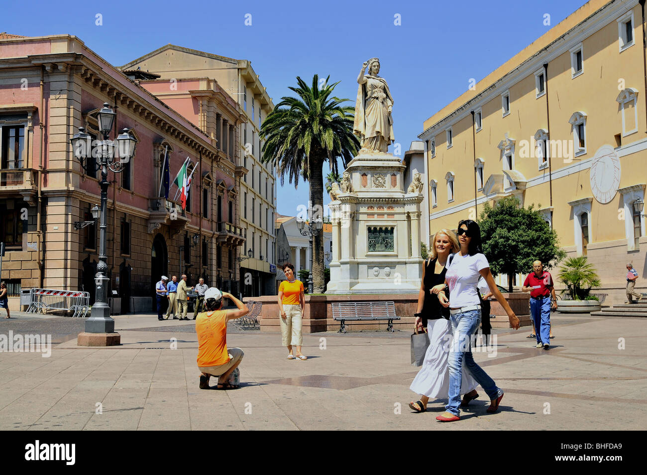 Un monumento e la gente sulla soleggiata Piazza Eleonora, Oristano, Sardegna, Italia, Europa Foto Stock