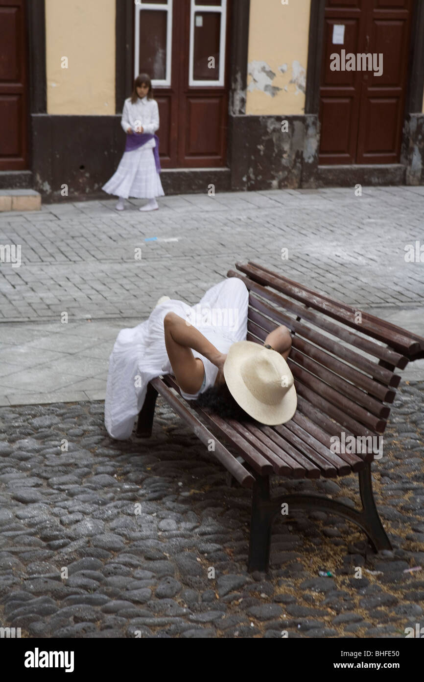 Donna avente una siesta su un banco, festival locale, revival del rimpatrio per gli emigranti, Fiesta de los Indianos, Santa Cruz de Foto Stock